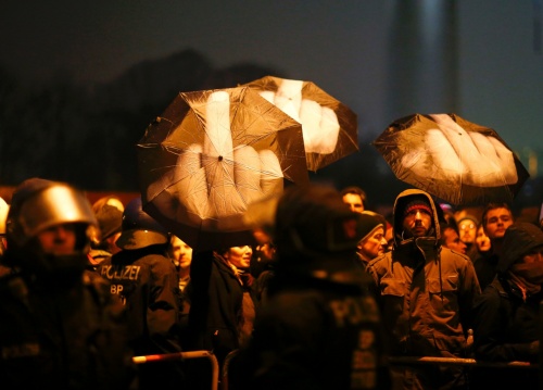 Demonstrators hold umbrellas as they protest in Berlin | Hannibal Hanschke/Reuters
