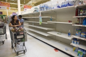 The original high resolution photo. Original caption: “A shopper passes empty shelves while looking for bottled water at a Stop and Shop at Rockaway Beach in New York, August 26, 2011. As North Carolina braced on Friday for a direct hit from Hurricane Irene, cities along the East Coast were on alert and millions of beach goers cut short vacations to escape the powerful storm. With more than 50 million people potentially in Irene's path, residents stocked up on food and water and worked to secure homes, vehicles and boats. States, cities, ports, oil refineries and nuclear plants scrambled to activate emergency plans.”| Allison Joyce/Reuters
